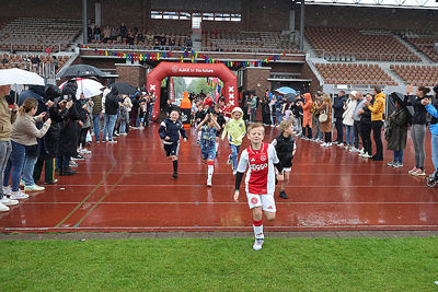 Onder luid applaus en in de regen het veld op. © De Brouwer